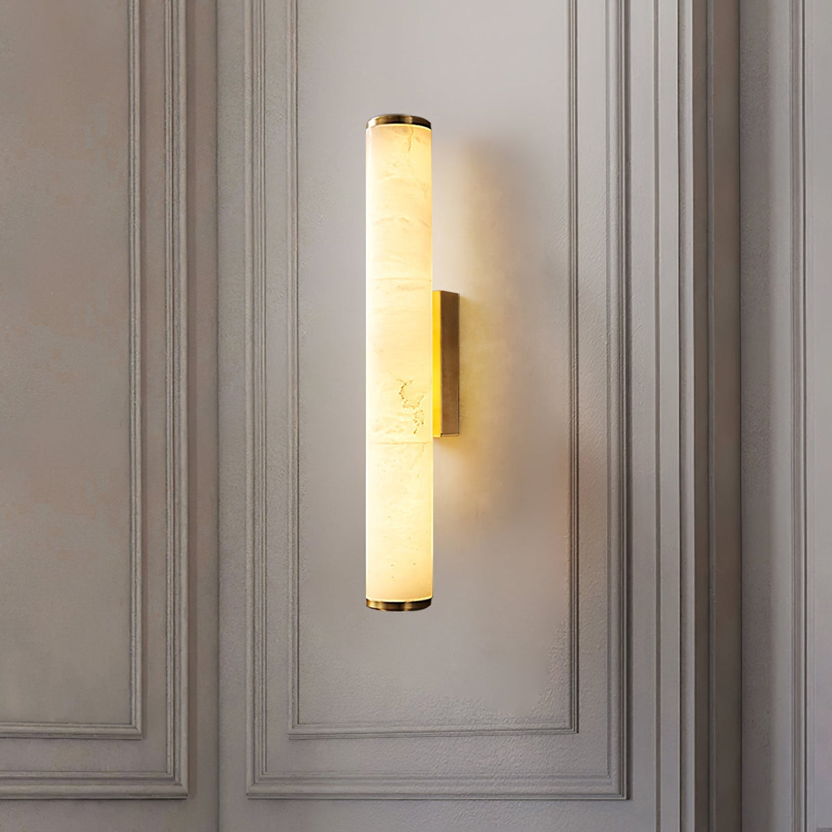 Alabaster cylinder aerq wall sconce installed vertically on a classic light grey panelled wall