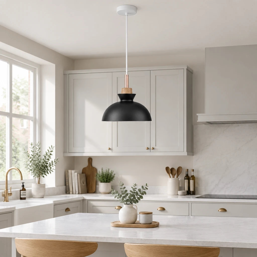 Black dome pendant light with copper socket and wood ring collar hanging in a modern British minimalist kitchen
