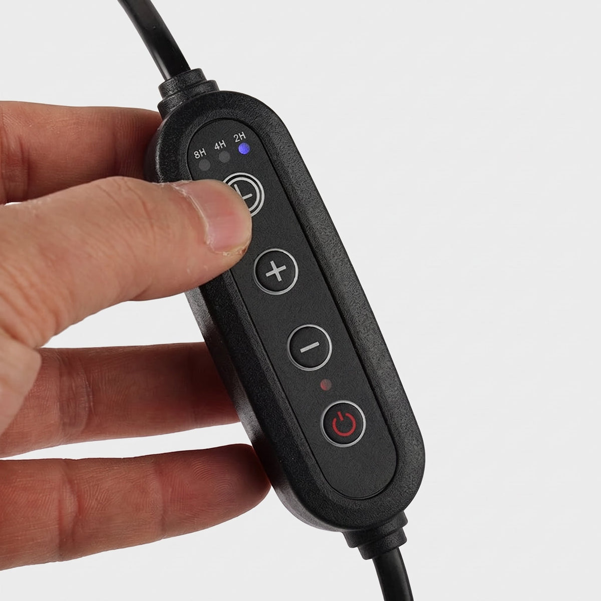 Hand pressing the timer button on the Ambra candle warmer lamp cable controller with 2H, 4H and 8H settings