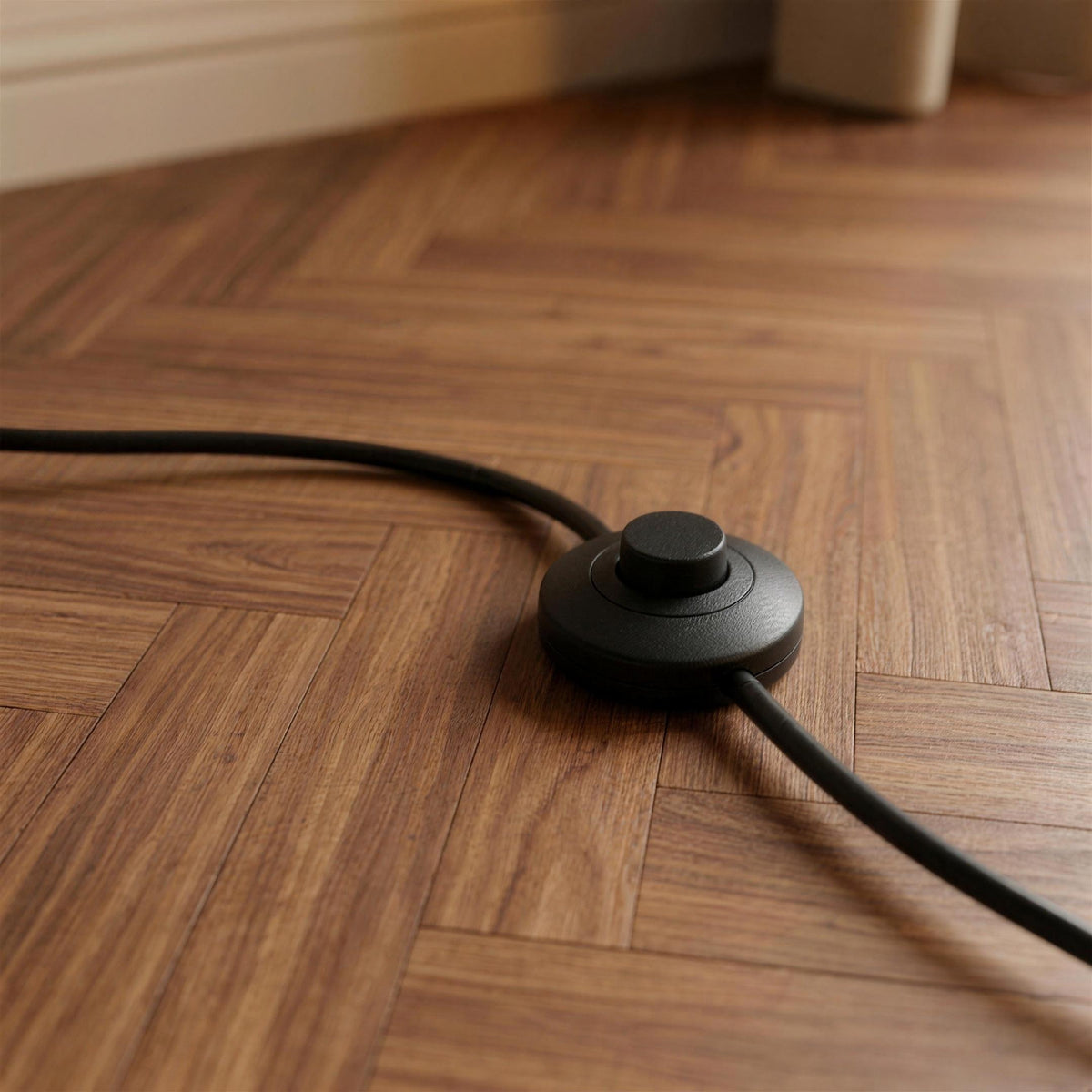 Close-up of the Ardo arc floor lamp inline foot switch on the black cable