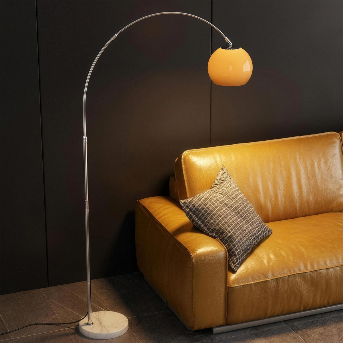 Ardo orange arc floor lamp beside a mustard yellow leather sofa in a dark living room