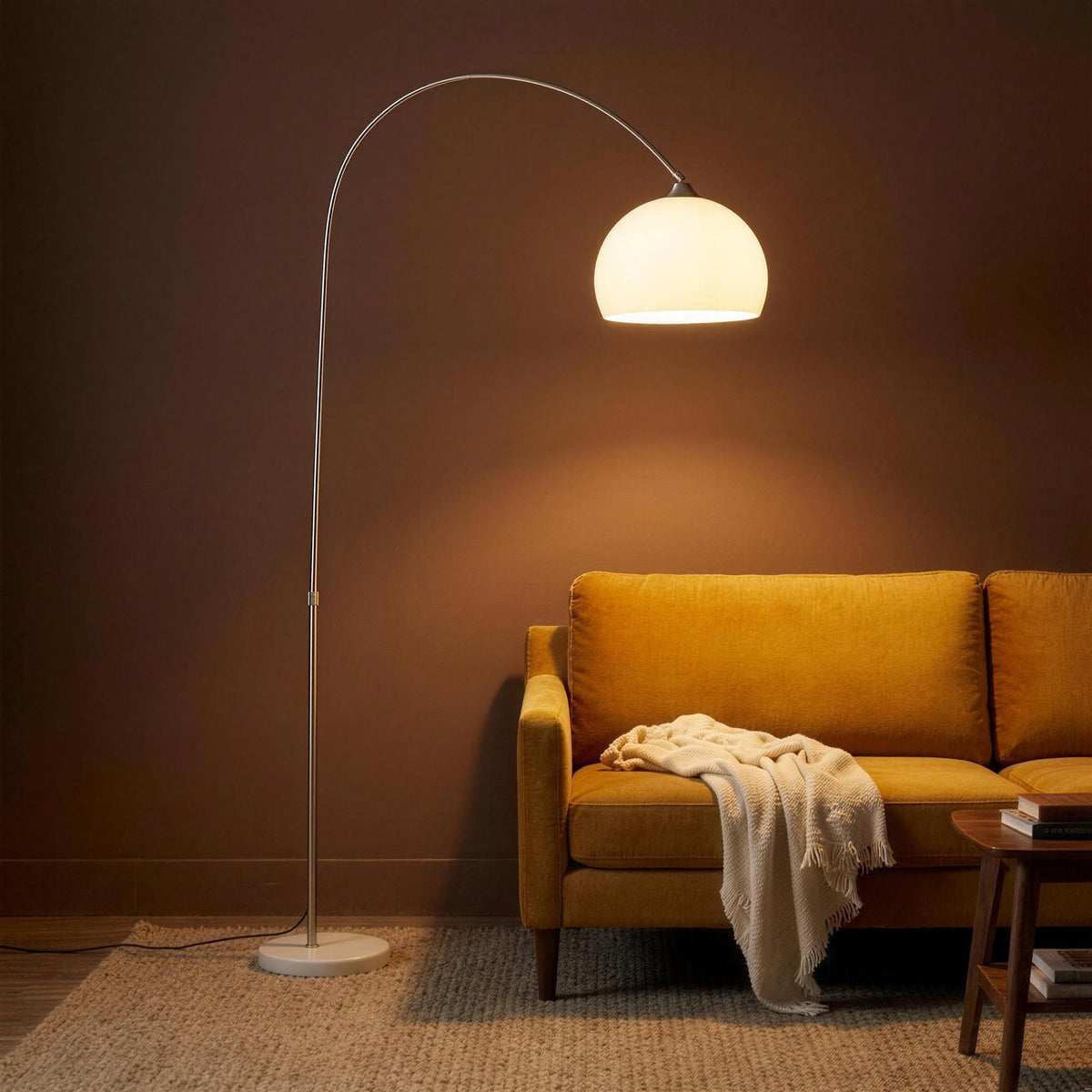 Ardo white dome arc floor lamp with a white marble base lit beside a mustard sofa