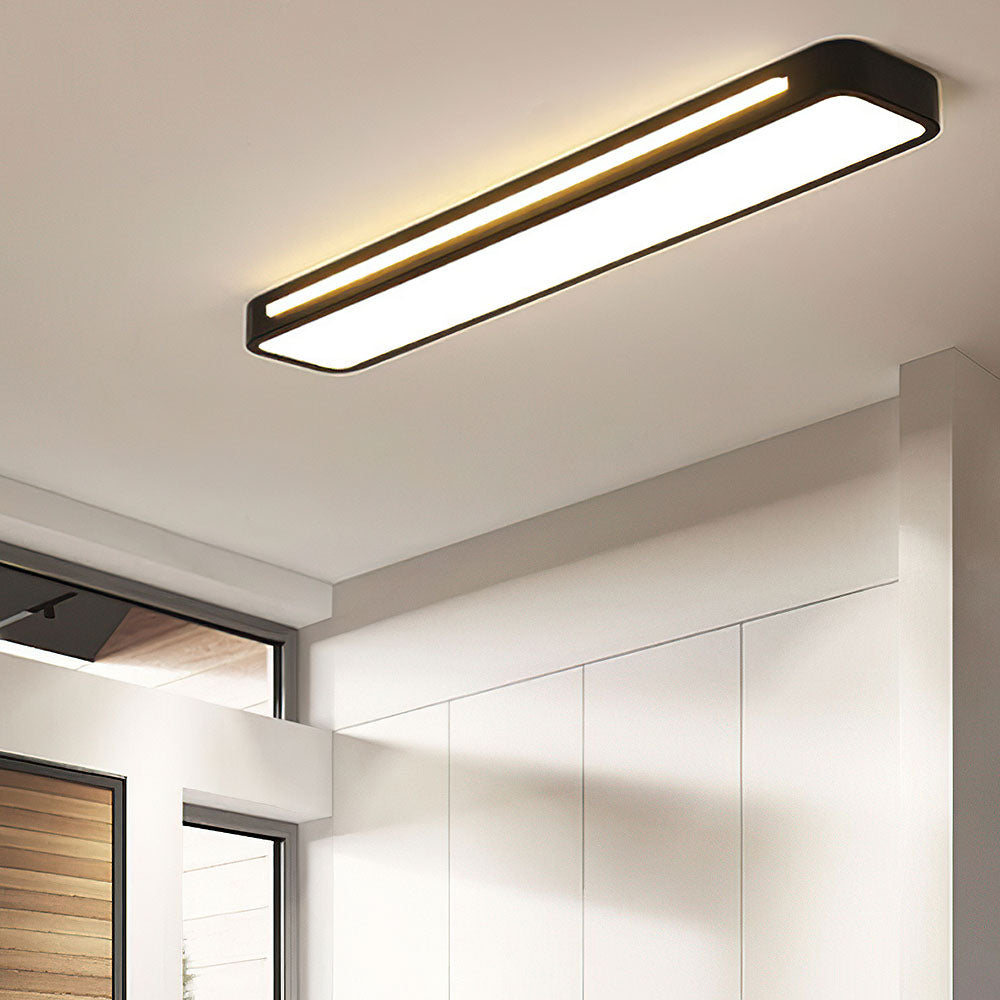 Minimalist black linear LED atio ceiling light providing task lighting in a modern kitchen corridor
