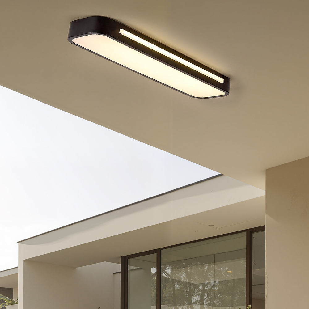 Minimalist black linear LED atio ceiling lamp installed in a modern architectural living space
