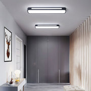 Two modern black linear LED flush mount atio ceiling lights illuminating a contemporary minimalist hallway