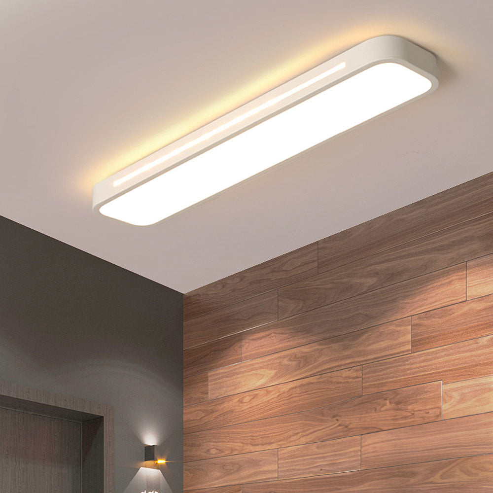 Modern white linear LED flush mount atio ceiling light illuminating a room with wood panelling