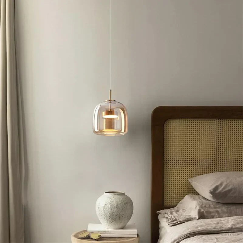 Single beqi amber tinted glass pendant styled as an elegant, space-saving bedside reading light
