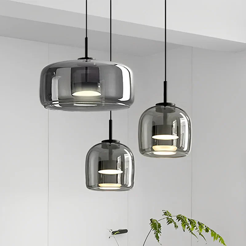 Three smoke grey beqi double-layer glass pendants illuminating a contemporary kitchen island