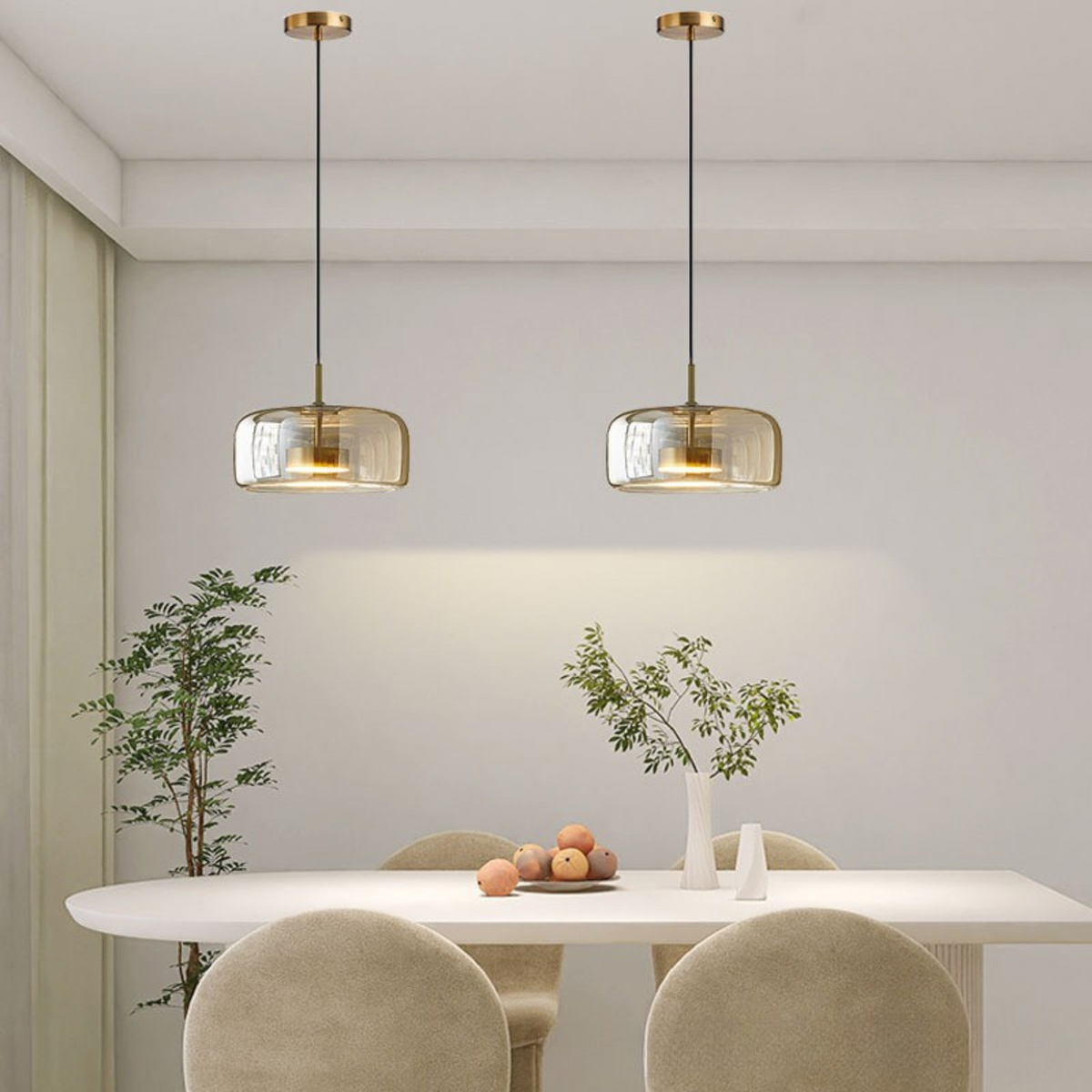 Pair of wide beqi amber glass pendant lights providing warm illumination in a neutral dining room