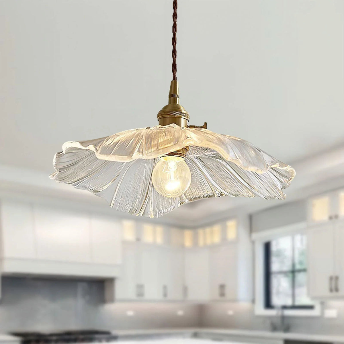Clear glass bila floral pendant light providing elegant illumination over a white kitchen island