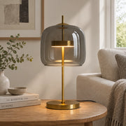 Brolt Smoke Grey glass table lamp with gold-finish iron base on a coffee table in a modern British minimalist living room