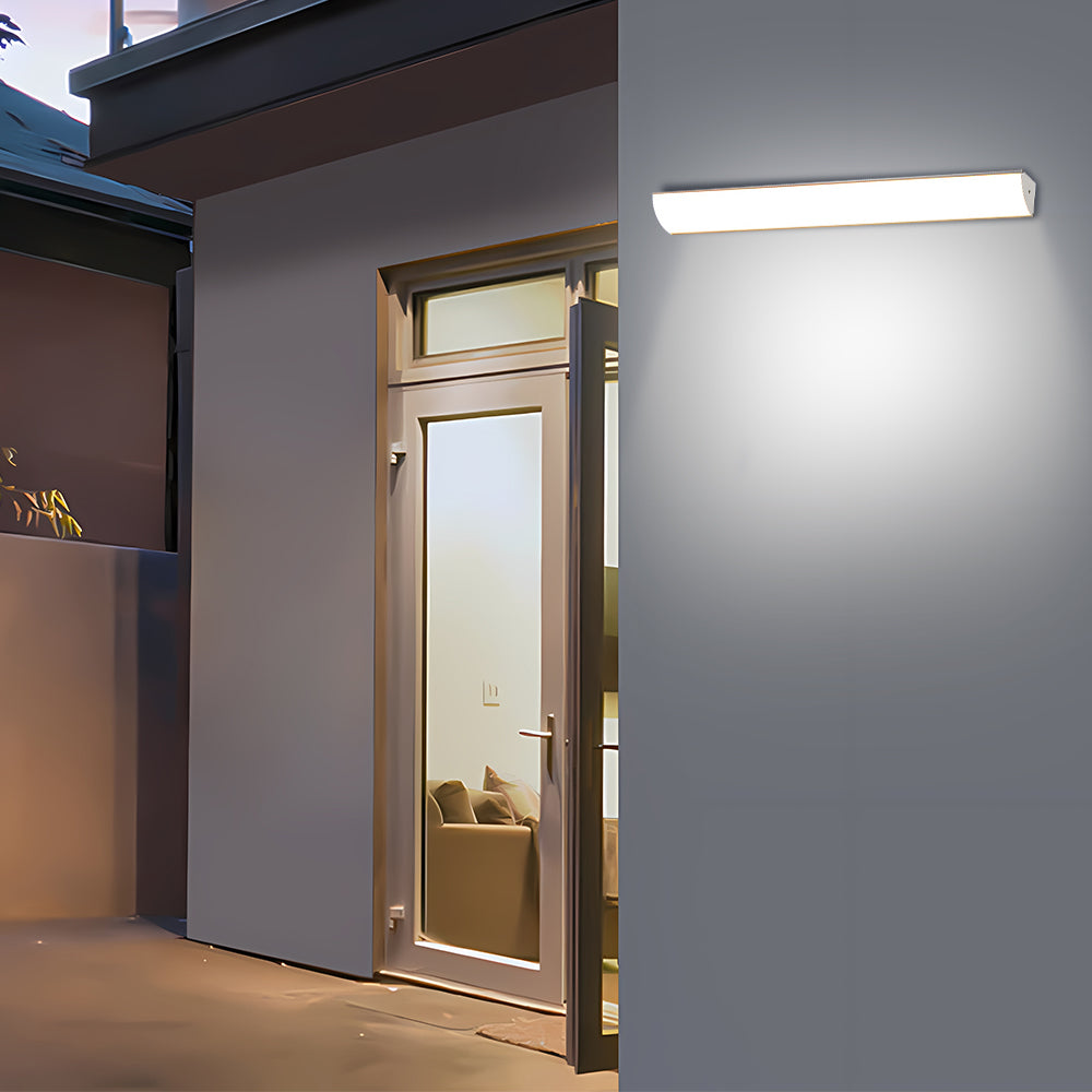 Horizontal linear LED bubce wall sconce illuminating a residential back door entrance