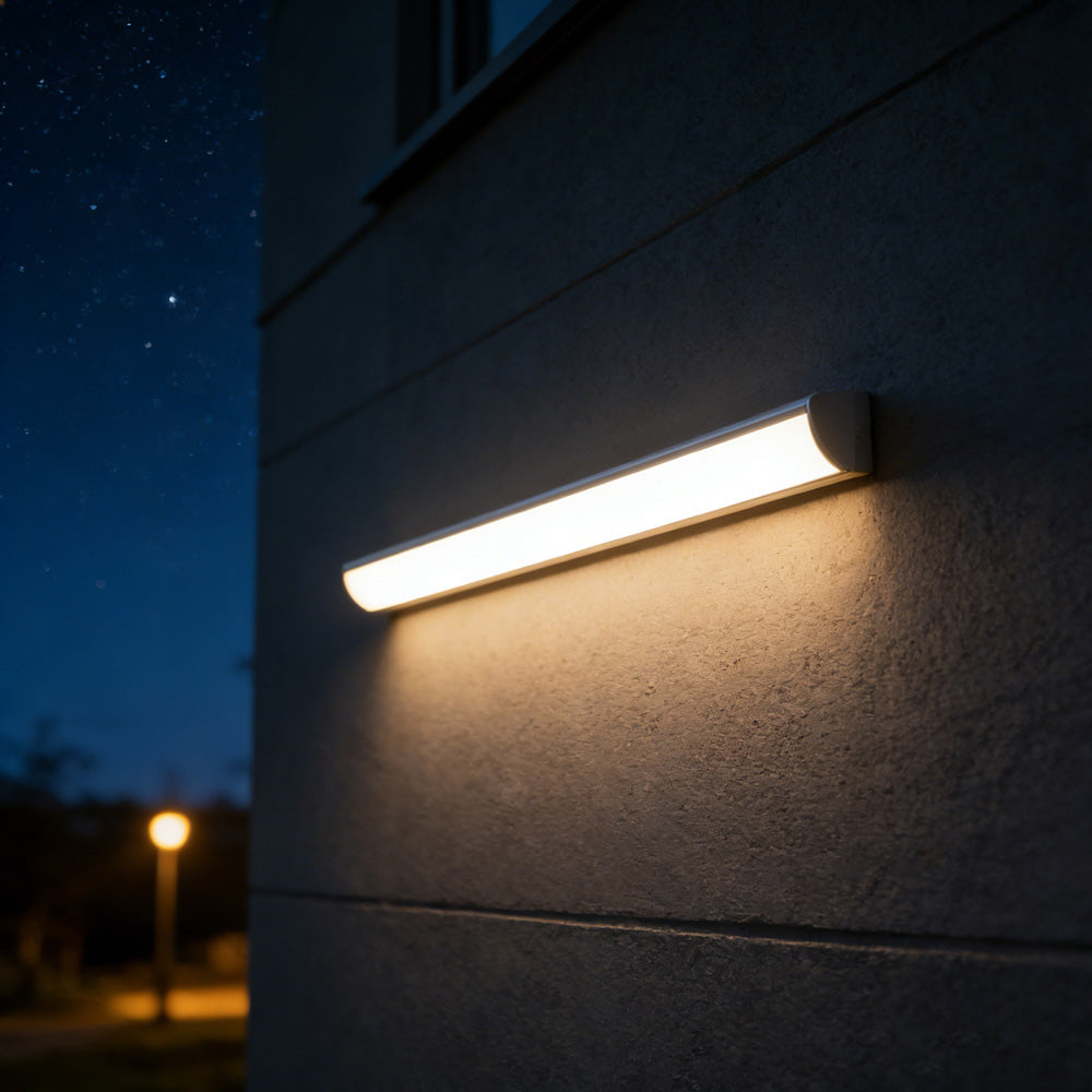 Long luminous bubce LED bar mounted horizontally on a dark architectural outdoor wall