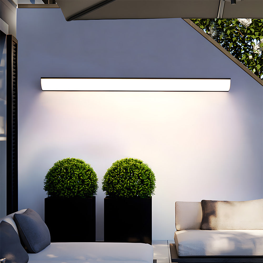 Modern exterior bubce wall light mounted horizontally above twin decorative garden planters