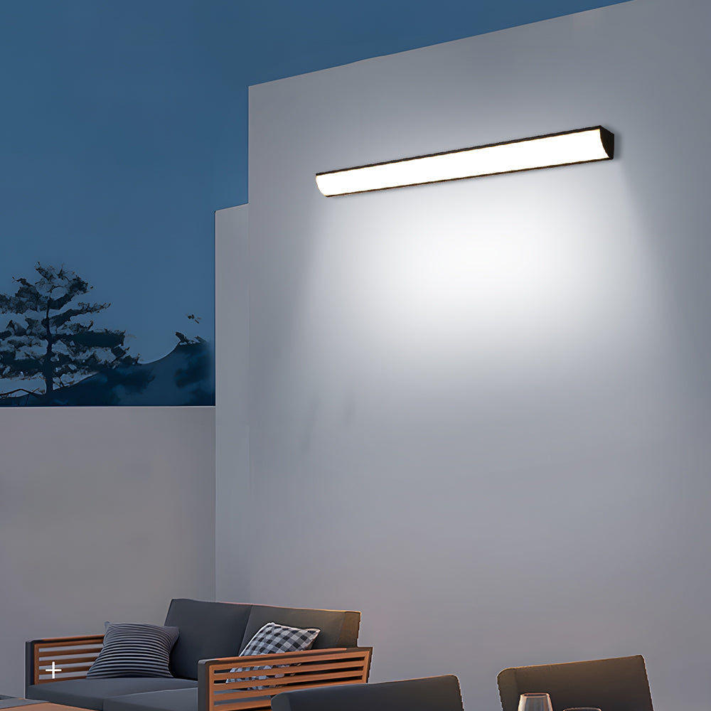 Modern long outdoor bubce wall sconce providing bright ambient illumination at dusk