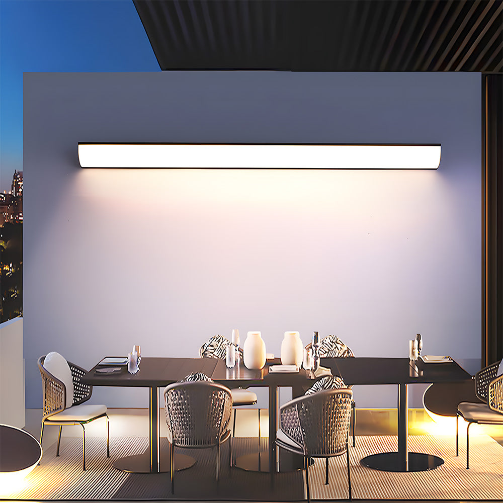 bubce long linear outdoor wall light illuminating an elegant alfresco dining table setting