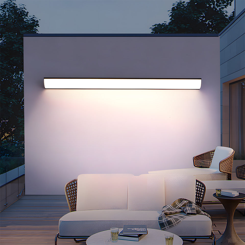 Modern linear bubce wall sconce providing bright illumination over a comfortable outdoor patio sofa