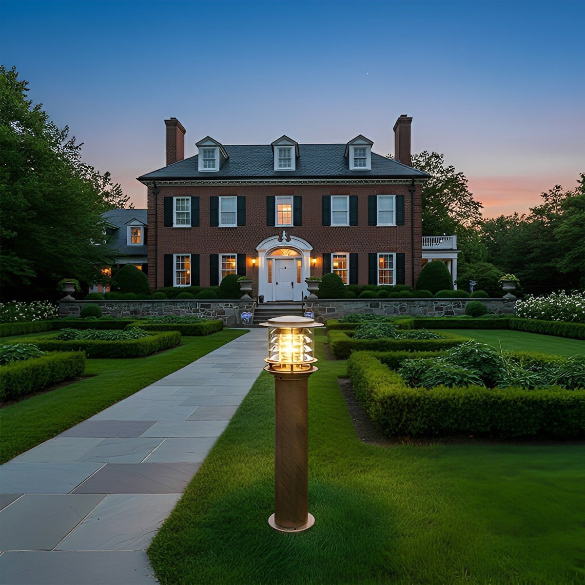 bulba bronze outdoor driveway bollard light centred on an elegant estate lawn at dusk