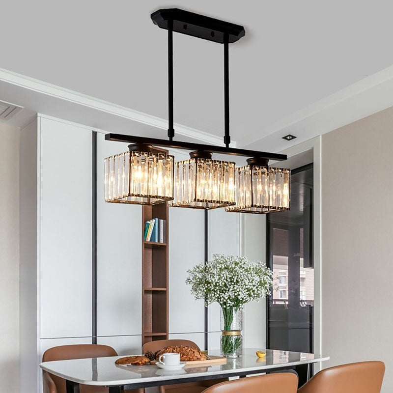 Black 3-light linear butel glass pendant providing warm lighting over a contemporary kitchen table