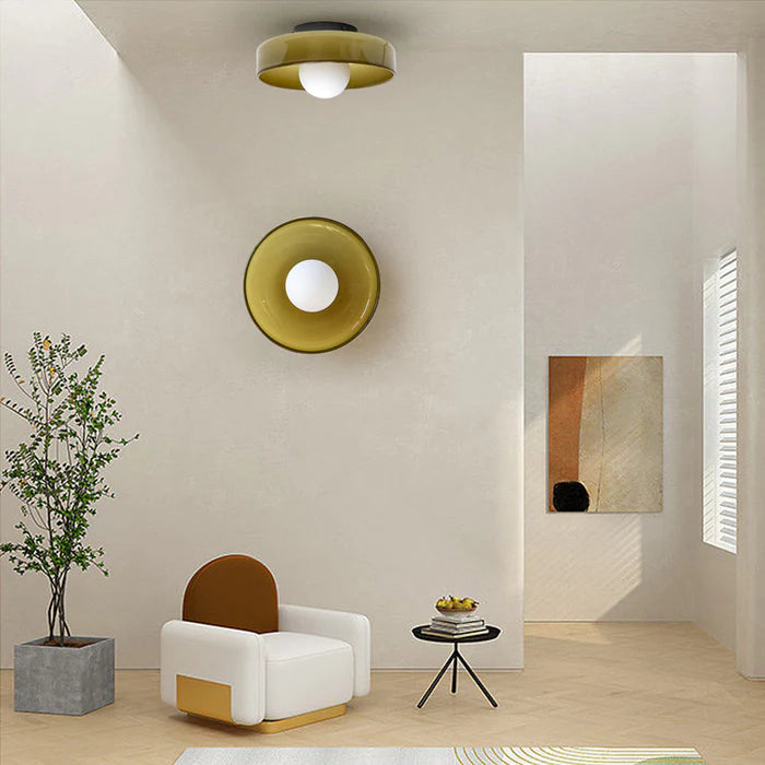 Olive green glass cenas wall sconce and matching ceiling light in a modern minimalist room