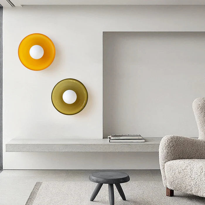 Orange and olive green glass cenas wall sconces styled together in a modern interior