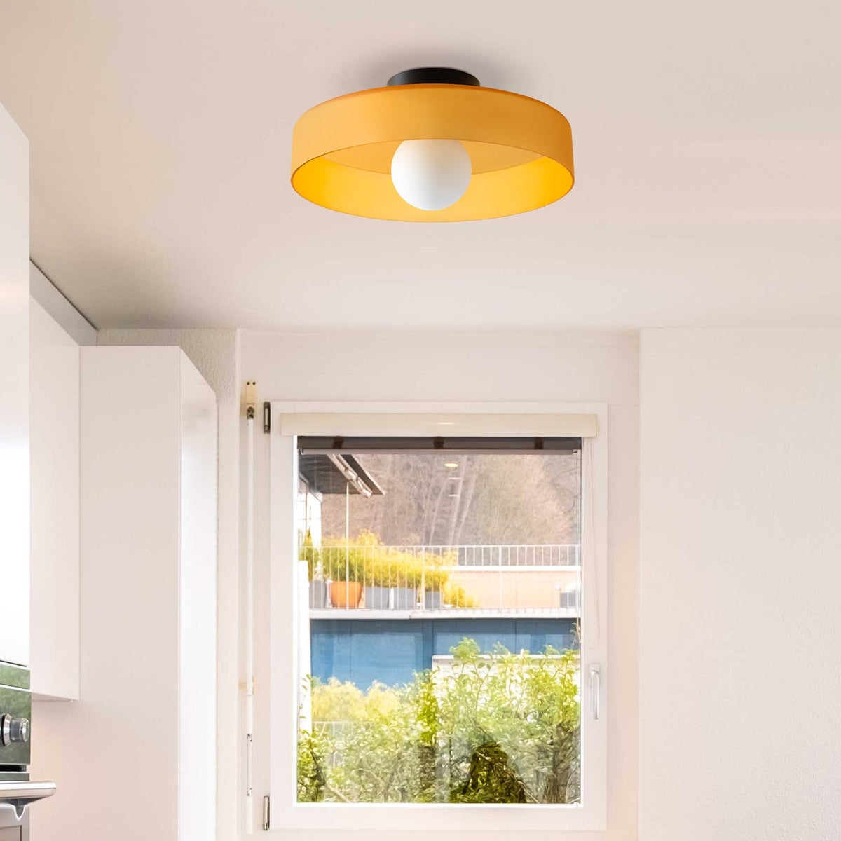Orange glass cenas ceiling lamp bringing a vibrant pop of colour to a modern kitchen entryway
