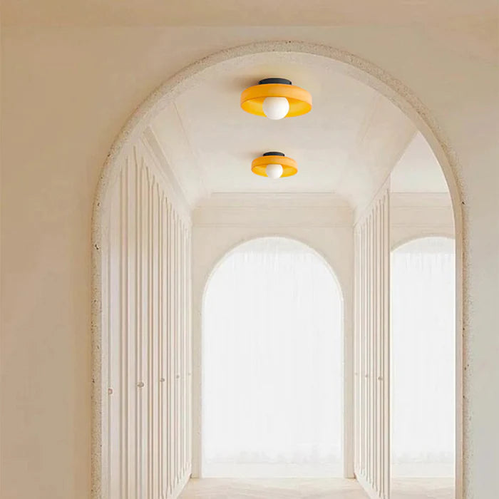 Pair of orange glass cenas ceiling lights illuminating a stunning arched architectural hallway