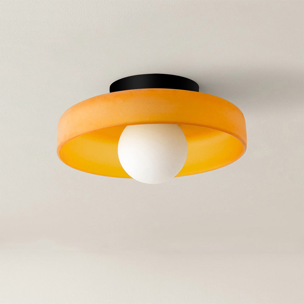 Orange glass disc cenas ceiling light with an opal globe isolated on a light background