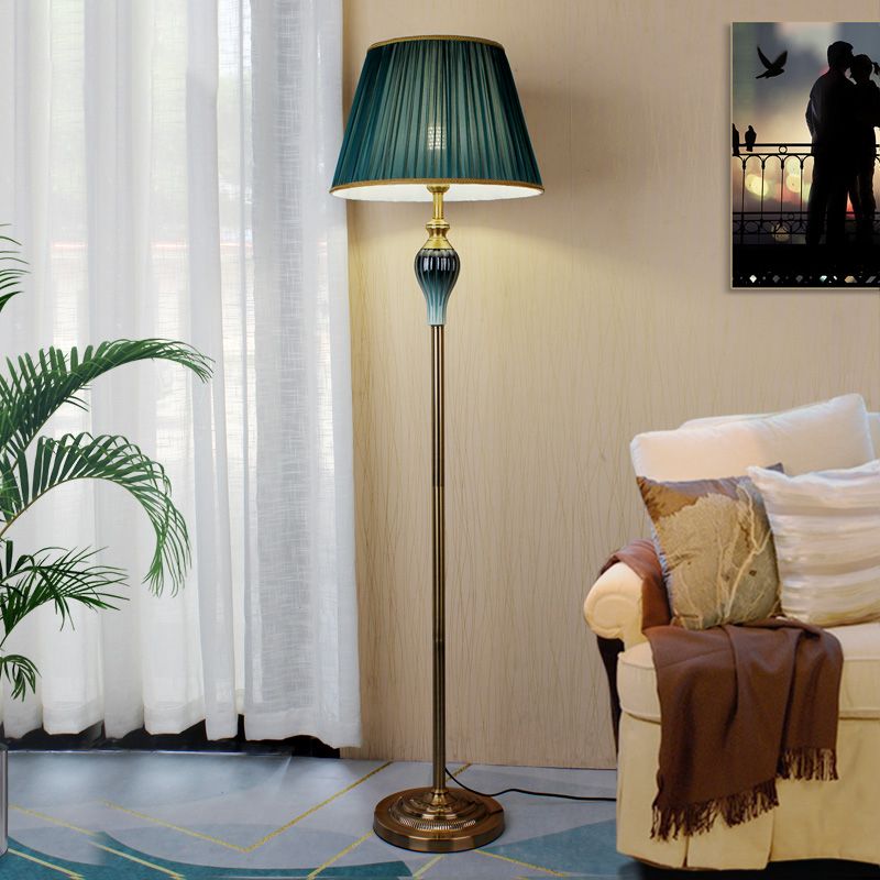 Military green classic dome shade reading cerf floor light positioned next to a living room sofa