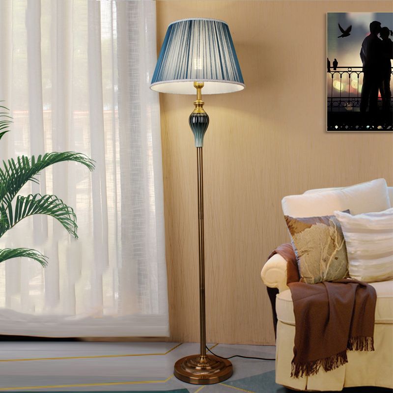 Blue pleated fabric standing cerf floor lamp adding an elegant touch of colour to a living room