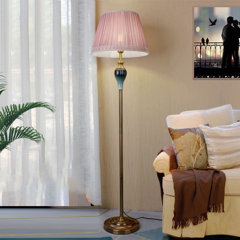 Pink retro pleated fabric cerf floor lamp providing warm ambient lighting in a bedroom or lounge