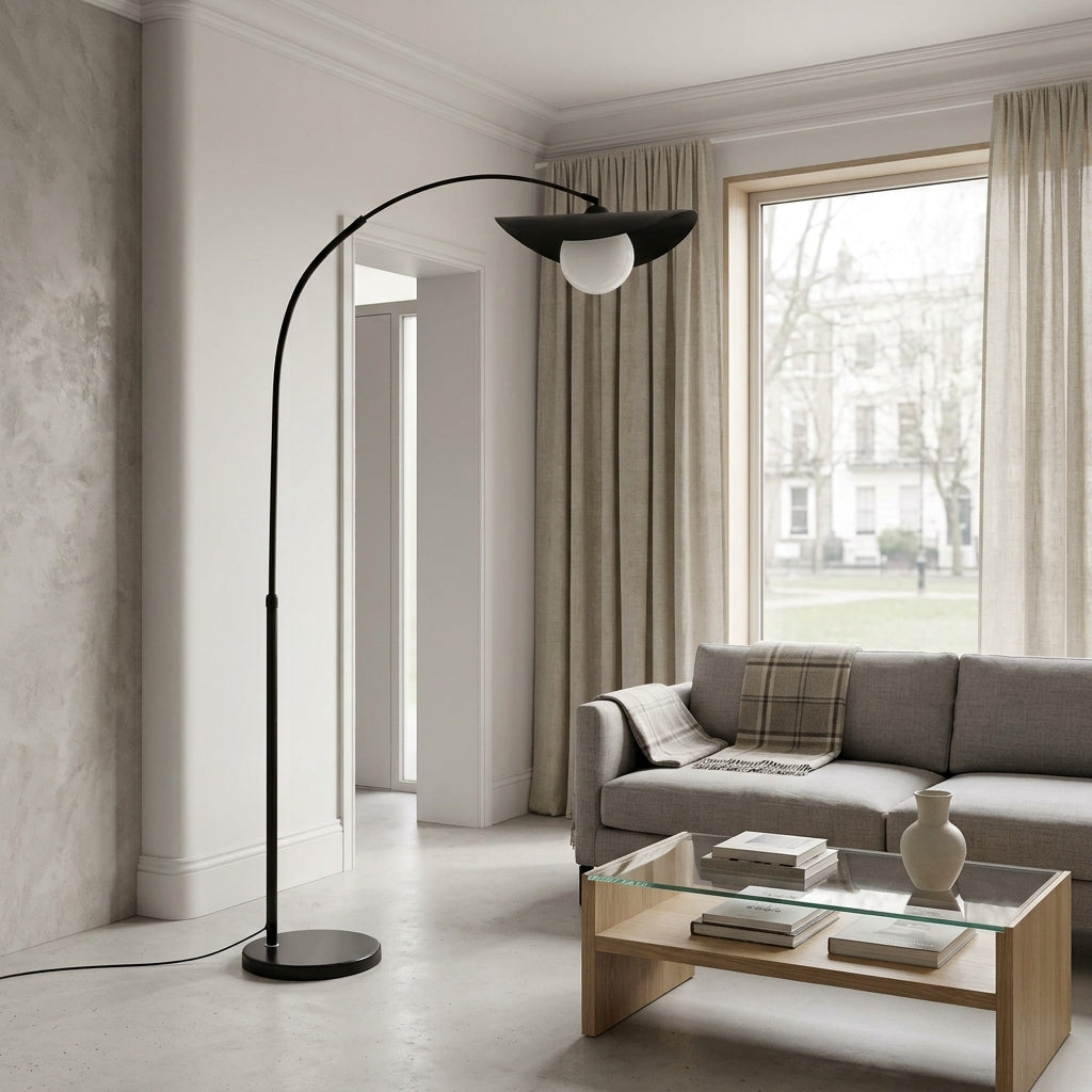 Clent black arc floor lamp over a grey sofa and glass coffee table in a neutral living room