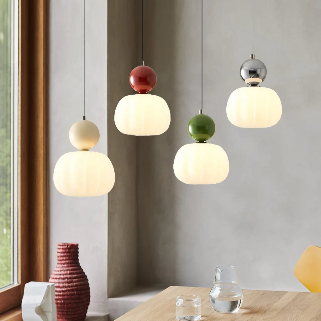 Mixed colour debz Art Deco pendant lights creating a playful, modern aesthetic over a wooden table
