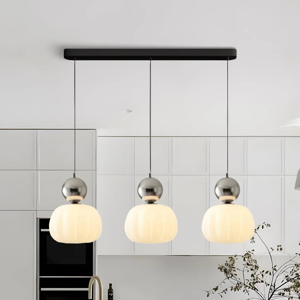 Silver three-head debz linear chandelier providing sophisticated lighting in a contemporary kitchen