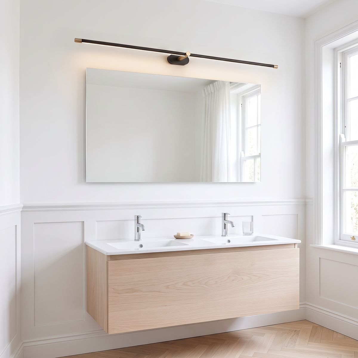 Doven black 128 cm linear LED wall light above a wide mirror and double basin vanity in a bright British bathroom with a herringbone floor
