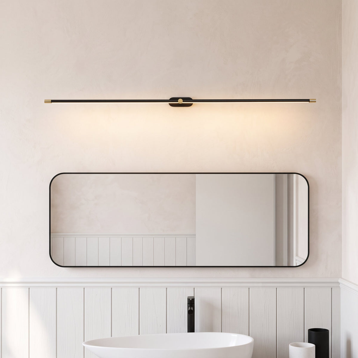Doven black linear LED wall light above a rounded rectangle mirror and white basin in a British bathroom