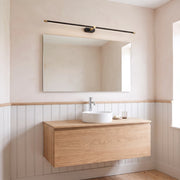 Doven black 128 cm linear LED wall light above a wide mirror and oak vanity with a vessel basin in a British bathroom