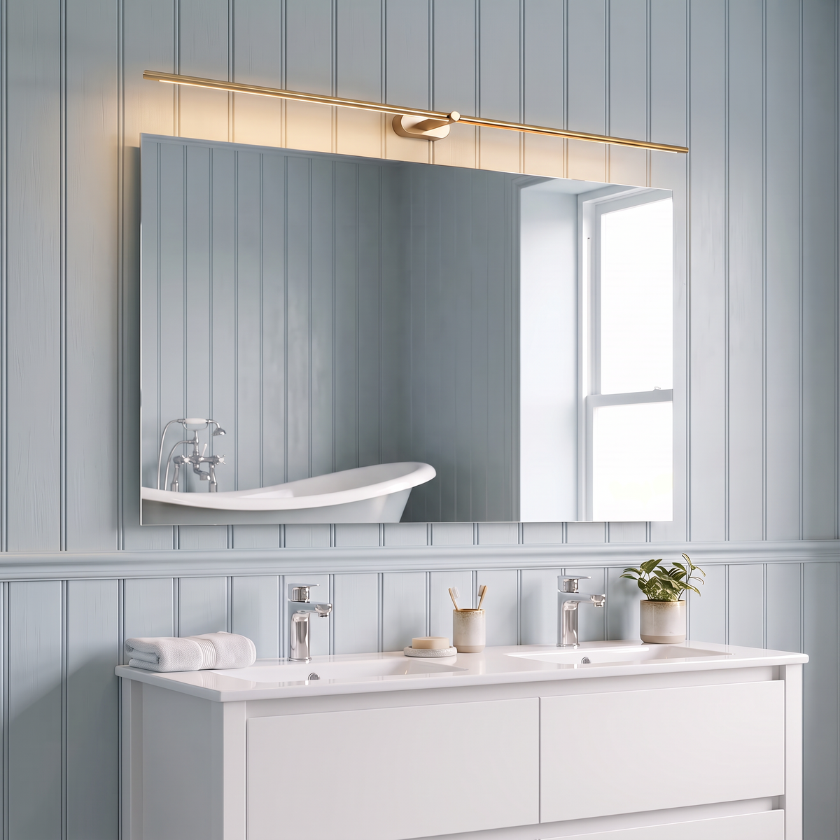 Doven gold-finish 128 cm linear LED wall light above a wide mirror and double basin vanity in a blue-grey panelled British en-suite