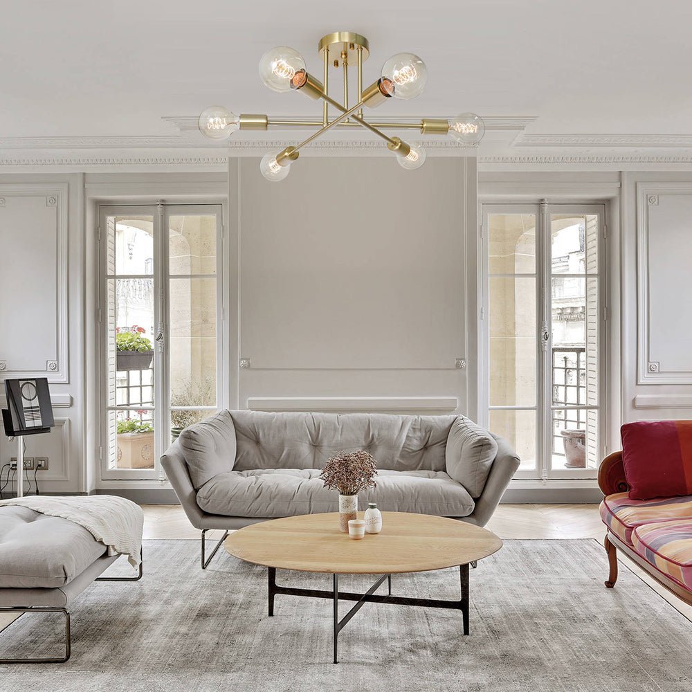 Brass Sputnik dubce chandelier providing warm ambient lighting over a coffee table in a modern grey living room
