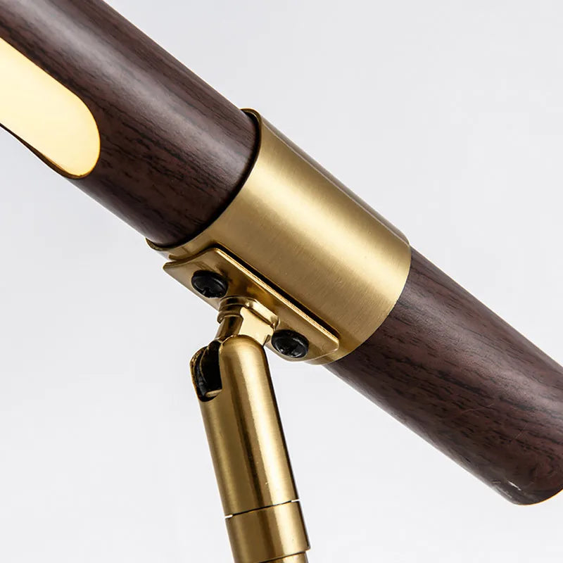 Close-up of the Elkon brass collar and pivot joint on the walnut light bar