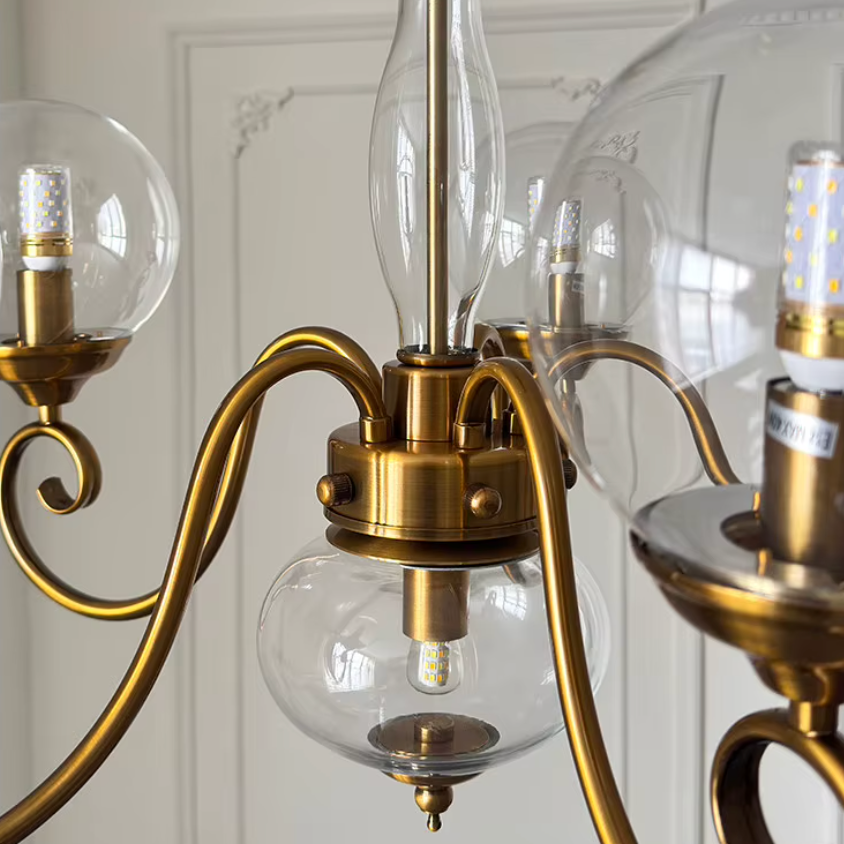 Elur chandelier Clear glass central column, brass-finish iron hub and lower globe, close-up