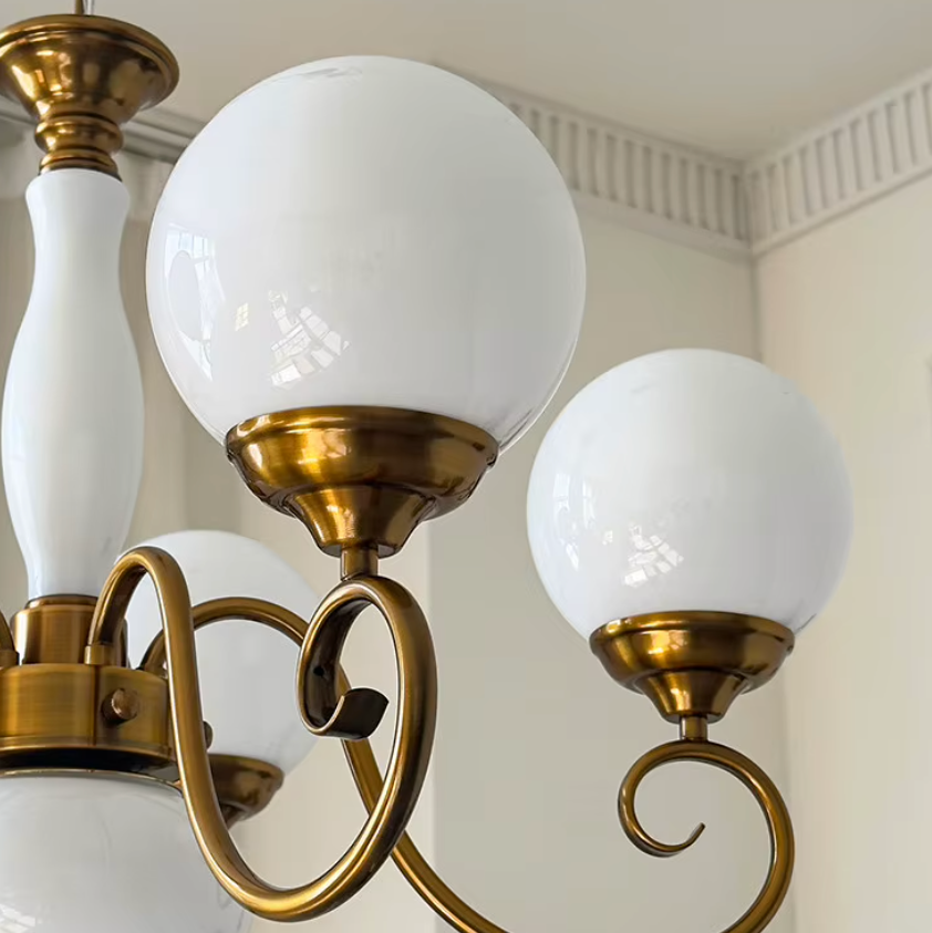 Elur chandelier Milky White glass globes and central column on brass-finish iron arms, close-up