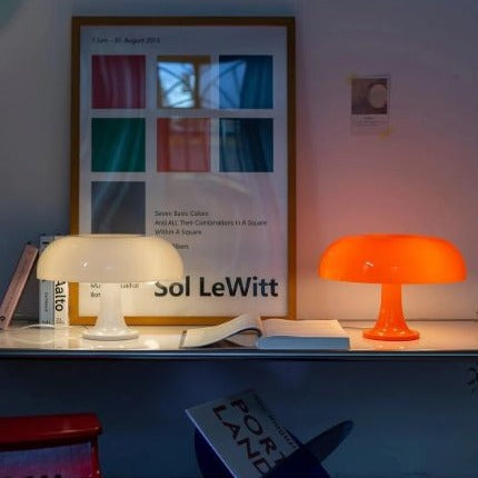 White and orange Space Age mushroom euter desk lamps styled together on a minimalist white shelf