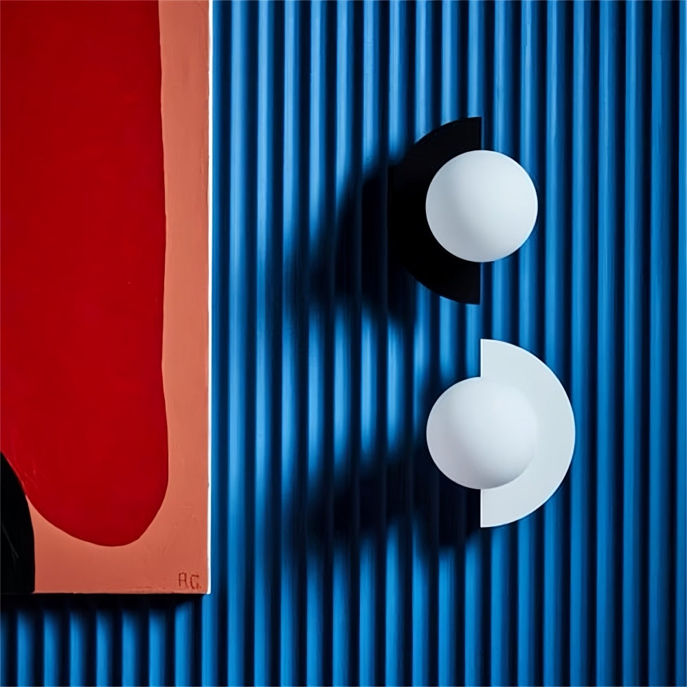 Black and white frosted glass globe fers sconces contrasting beautifully against a blue ribbed accent wall
