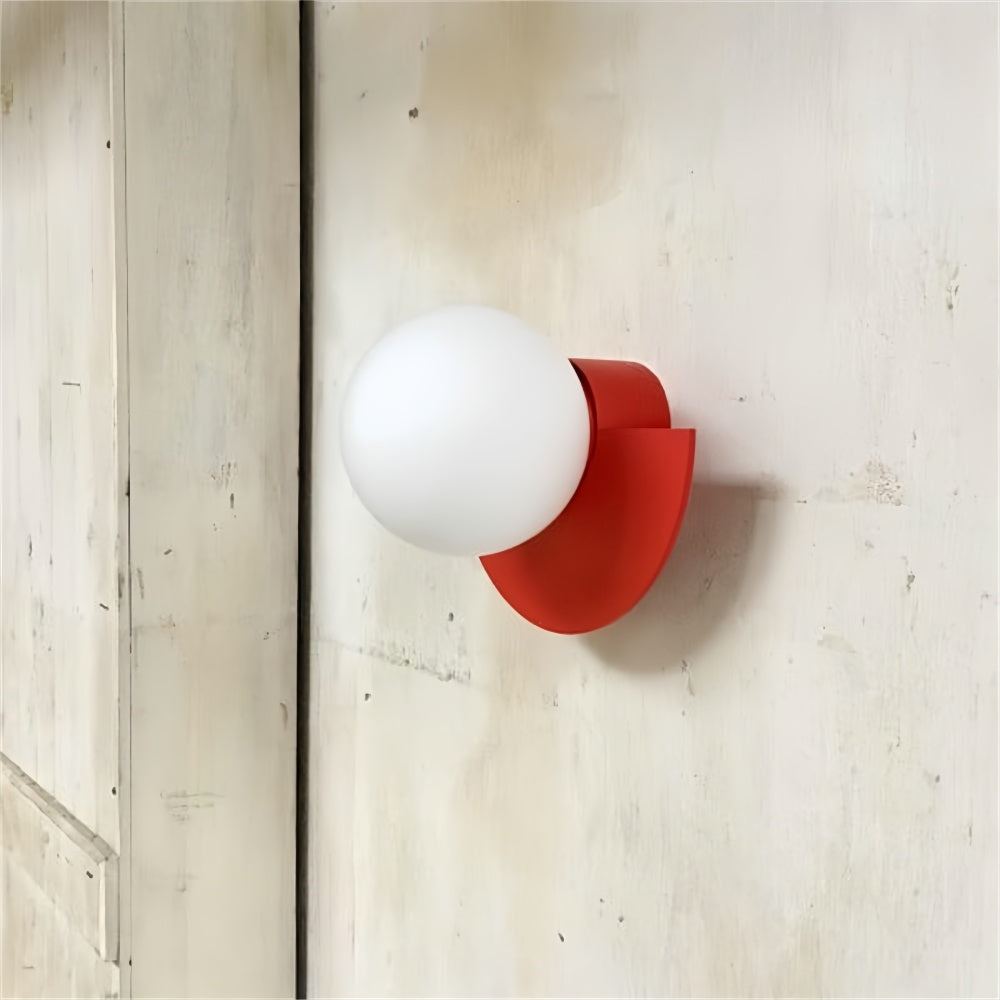Vibrant red semi-circle globe fers wall sconce mounted on an industrial concrete wall
