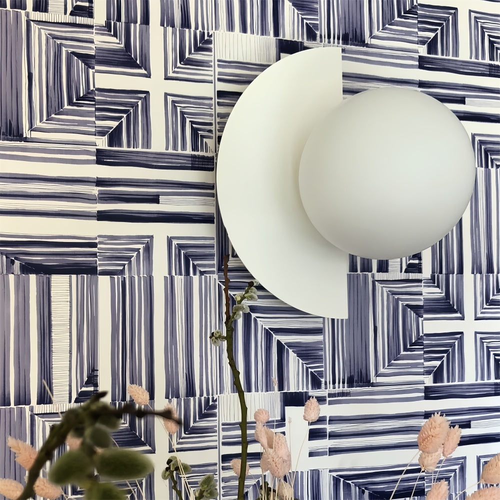 Clean white Bauhaus fers wall sconce styled perfectly against striking blue geometric wallpaper