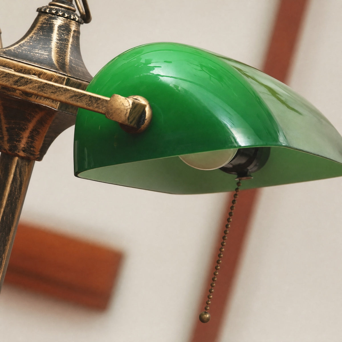 Close-up of a Gemma green glass lamp shade and brass arm