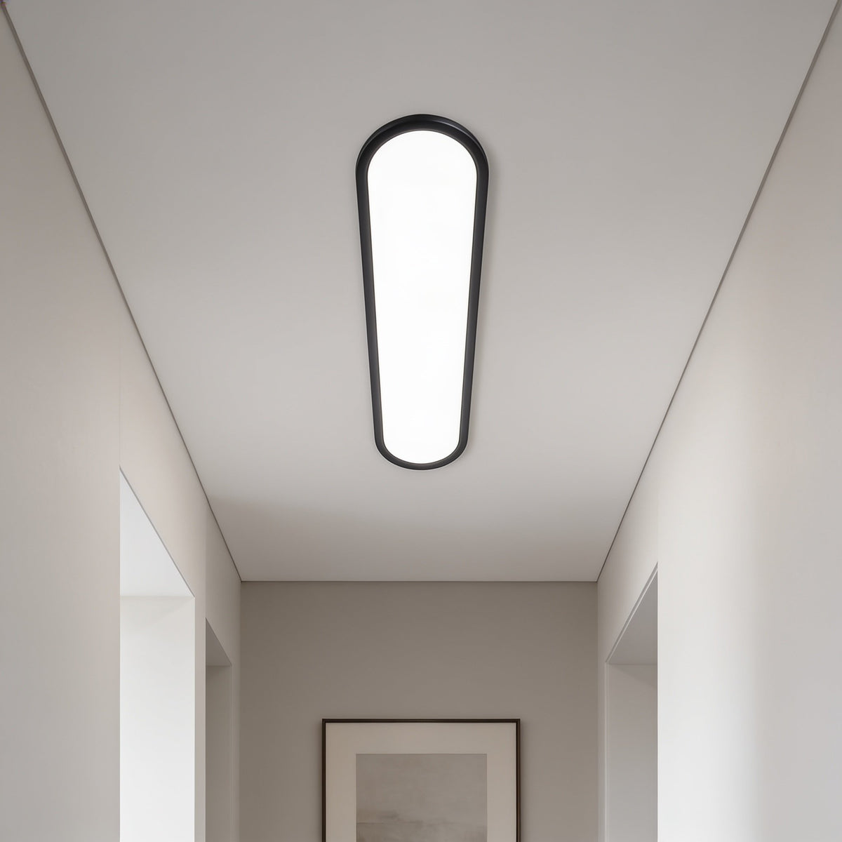 Grale black oval LED ceiling light in a narrow hallway with a framed print at the end
