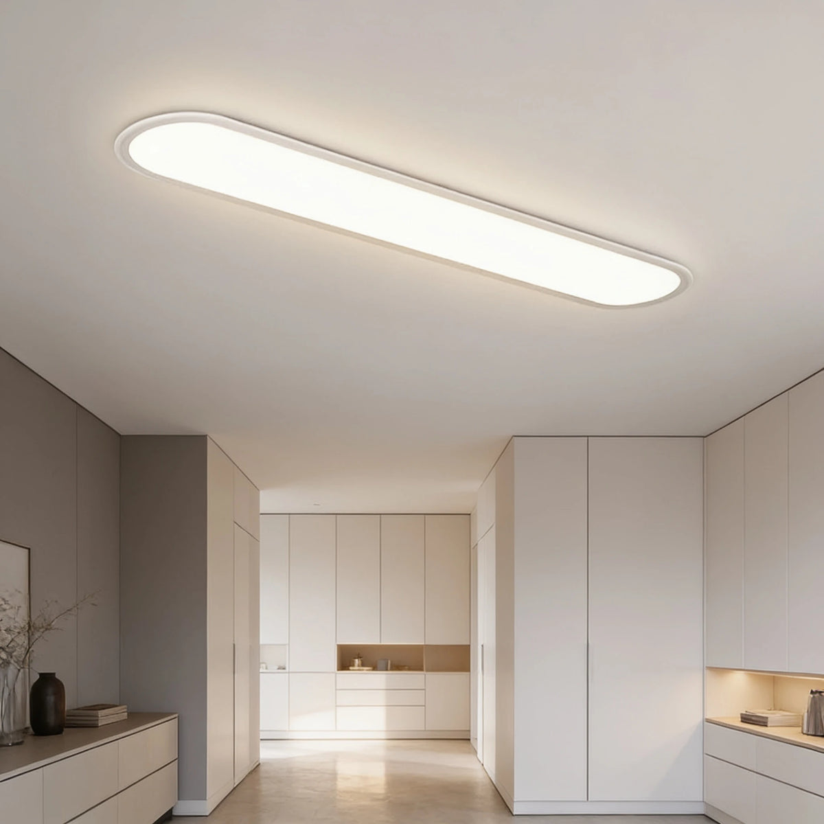 Grale white oval linear LED ceiling light above a bright open-plan hallway with built-in cupboards