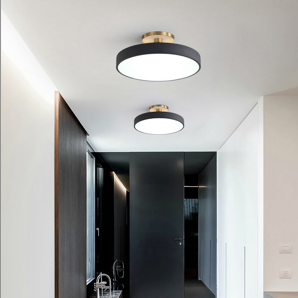 Pair of black circular guoj ceiling fixtures providing bright illumination in a modern dark hallway